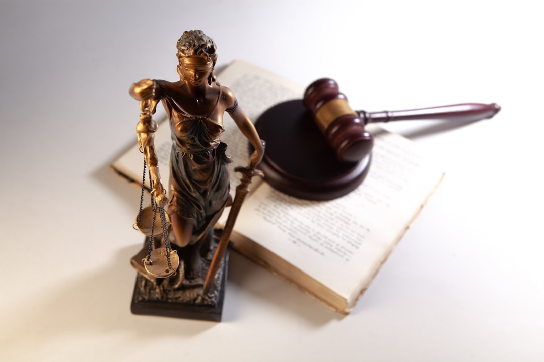 good conduct time — Statue of justice, gavel, and open book on table.