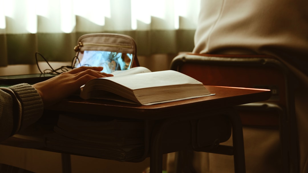 children parent prison — a person sitting at a table with a book and a laptop