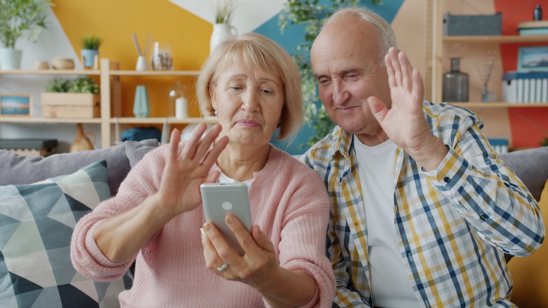 children parent prison — Elderly couple waving at smartphone screen